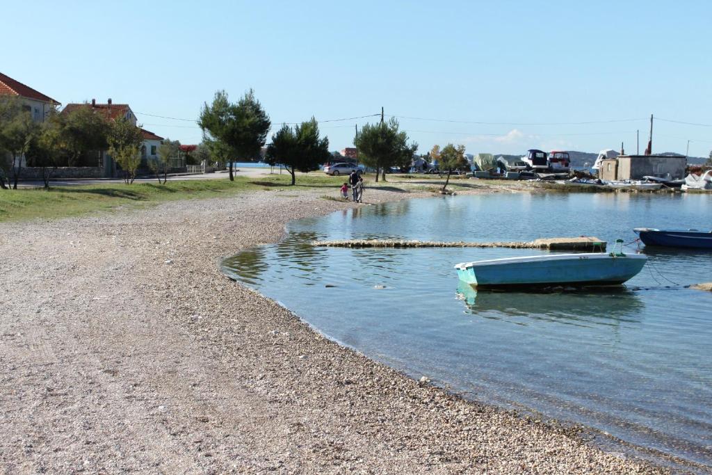 a boat sitting on the shore of a body of water at Studio Sukosan 14681a in Sukošan