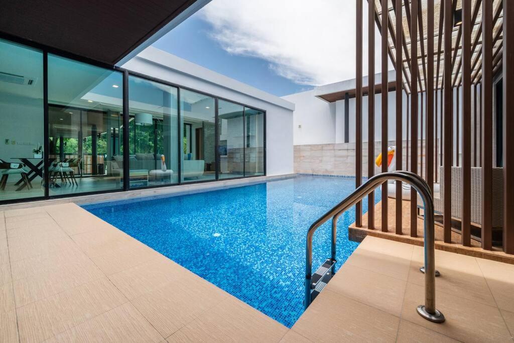 a swimming pool in the middle of a house at Mövenpick Pool Villa4BR-PrivatePool(SHA CERTIFIED) in Na Jomtien