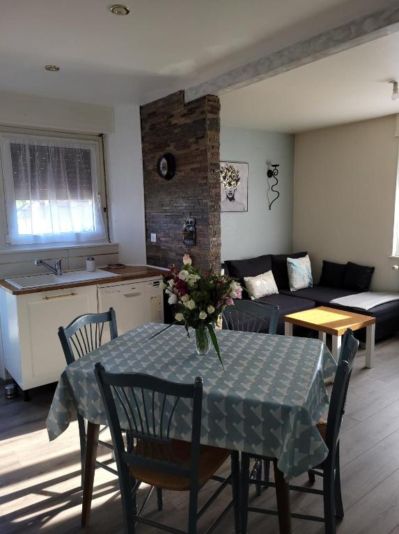 un salon avec une table et un canapé dans l'établissement Appartement Au Cigogneau Wifi-Netflix-Balcon-Parking, à Munster