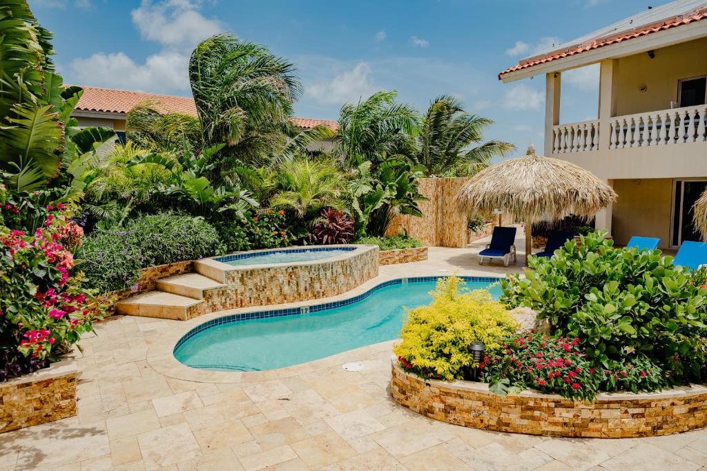 un cortile con piscina e una casa di Wonderful 2-bedroom apartment 2 km from Eagle beach a Palm Beach