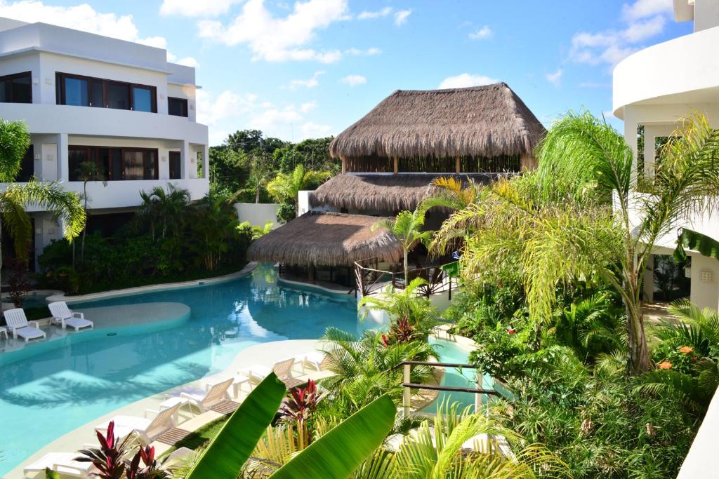 a large swimming pool in a tropical setting at Intima Resort Tulum Adults Only (Clothing Optional) in Tulum