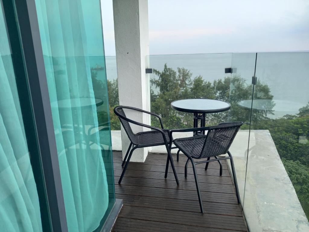 un tavolo e due sedie su un balcone con vista di Sunset View 969 PD Waterfront a Port Dickson
