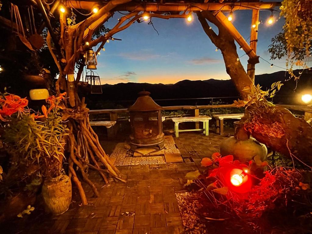 a patio with a table and a tree with lights at Kirinosato Takahara in Tanabe