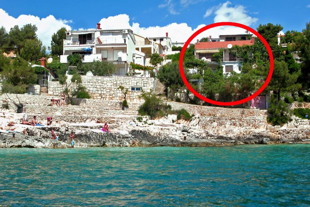 un círculo rojo en un edificio junto al agua en Apartments by the sea Rastici, Ciovo - 4818 en Trogir