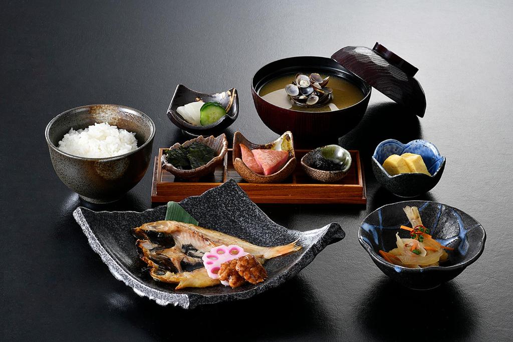 Shimane Hamada Washington Hotel Plaza في Hamada: مجموعة من أطباق الطعام على طاولة