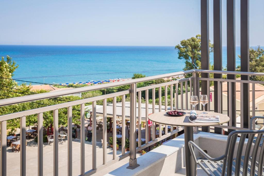 uma varanda com uma mesa e vista para a praia em Skala Hotel em Skála Kefalonias