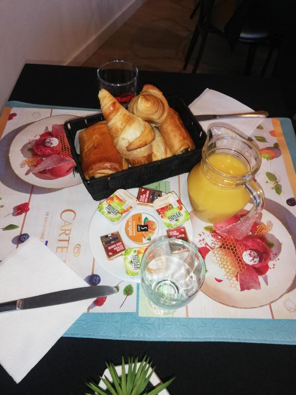 a table with a tray of pastries and a glass of orange juice at LE PATIO in Millau