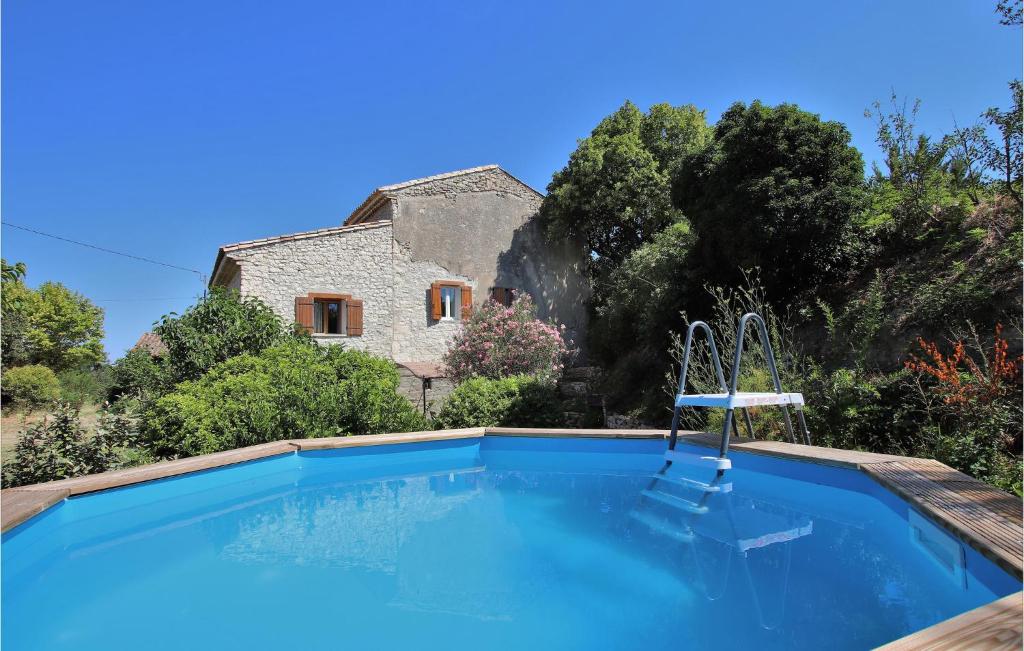 uma piscina em frente a uma casa de pedra em 2 Bedroom Beautiful Home In St Didier em Saint-Didier