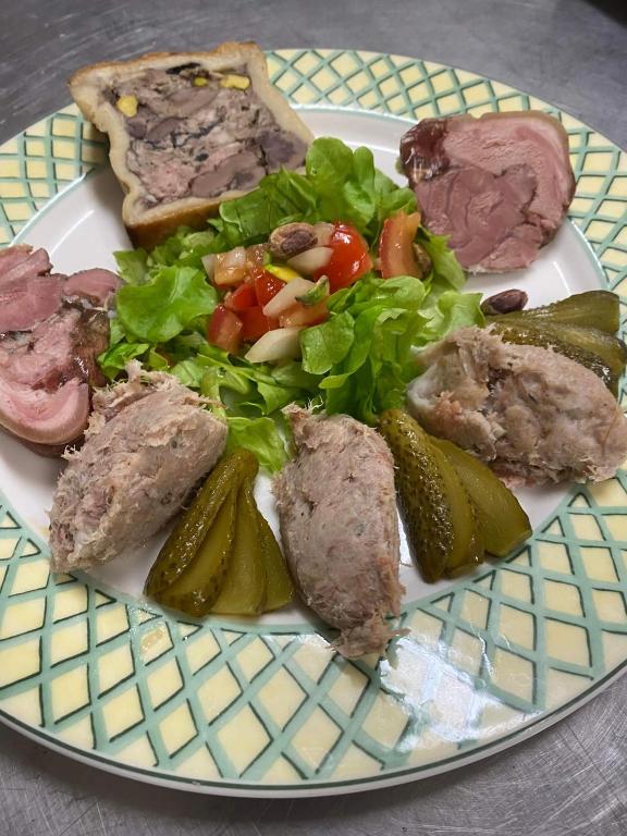 a plate of food with meat and a salad and pickles at LE PATIO in Millau