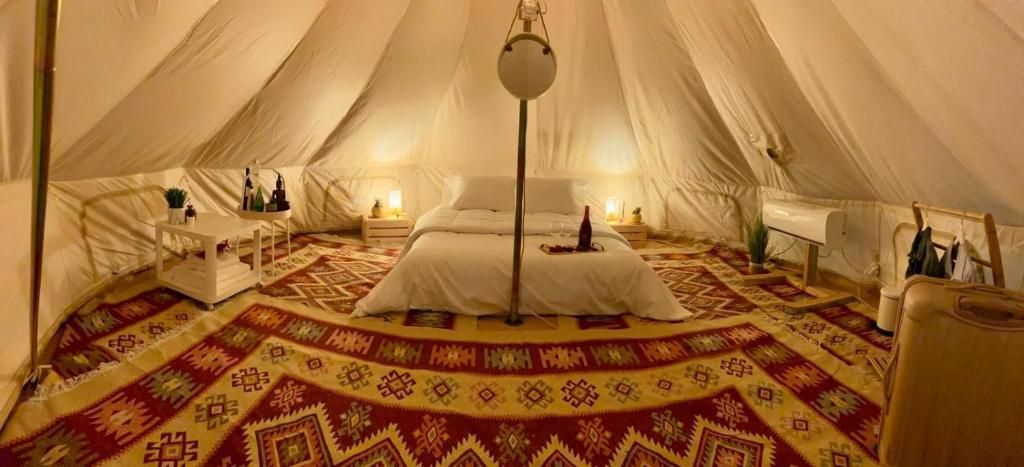 een slaapkamer met een bed in een tent bij נירוונה במדבר in Be'er Milka