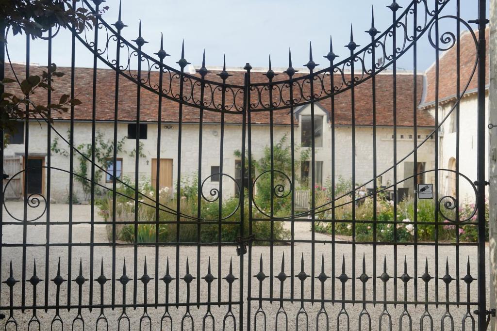 a black iron gate in front of a building at Ferme du bois de Veude in Anché