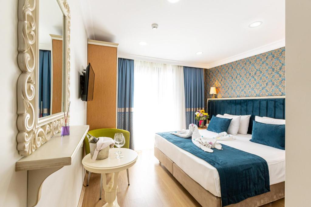 イスタンブールにあるクムル ホテルのベッドと鏡が備わるホテルルーム