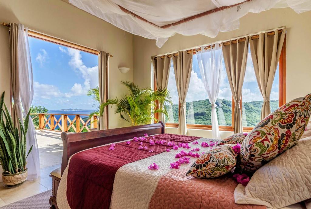 a bedroom with a bed with purple flowers on it at Sadewa Villa in Port Elizabeth