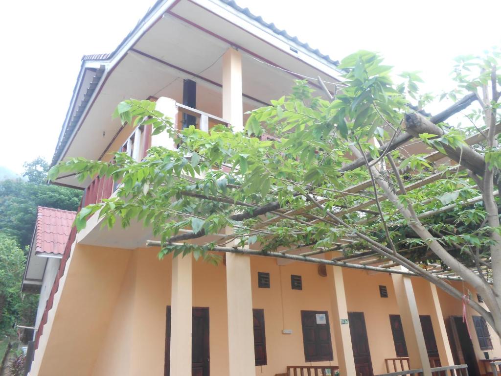 ein Gebäude mit einem Baum davor in der Unterkunft Sythane Guesthouse in Nongkhiaw