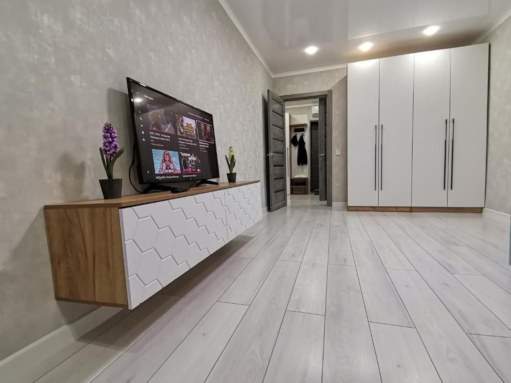 uma sala de estar com uma televisão de ecrã plano num balcão em Чистая уютная квартира! Рядом сквер,море em Aktau