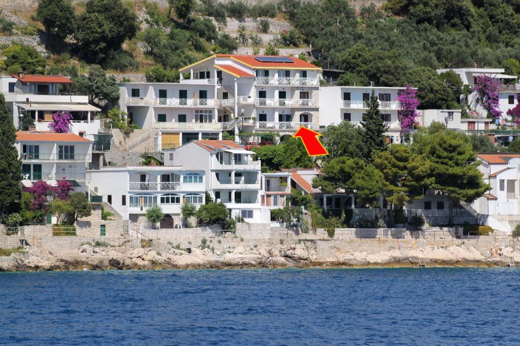 a group of houses on a hill next to the water at Apartment Drvenik Gornja vala 4890a in Drvenik