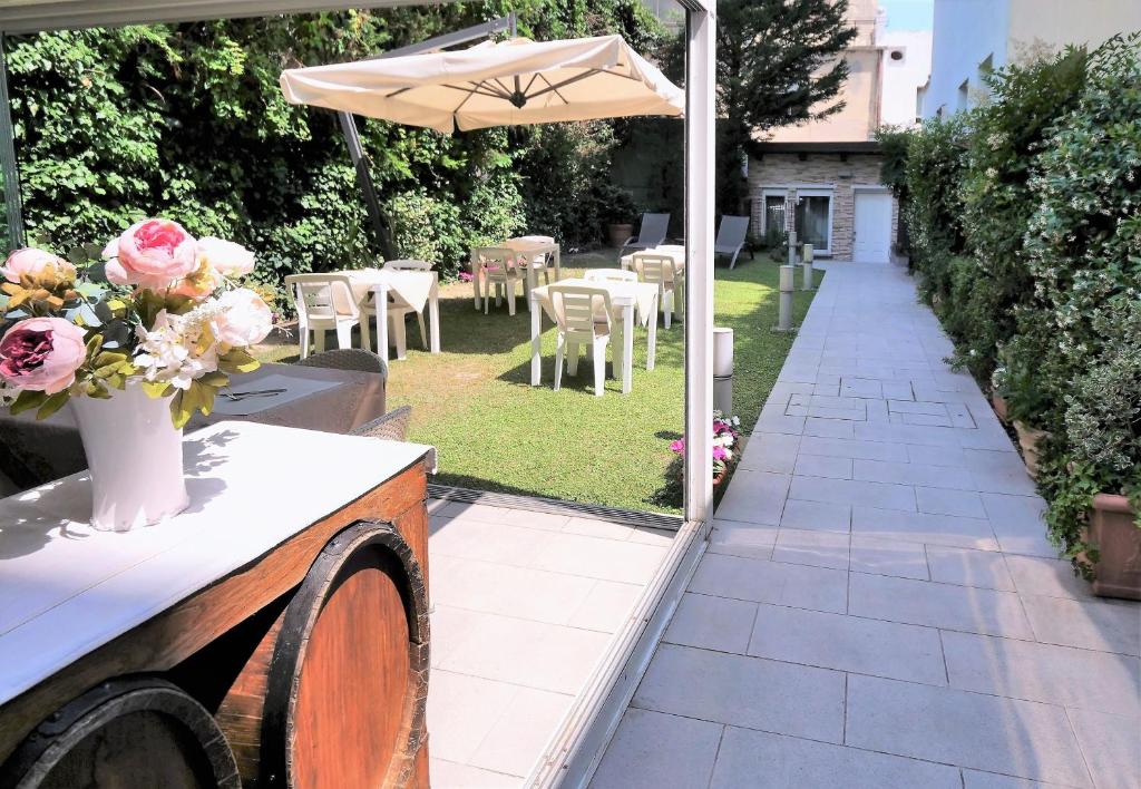 a patio with a table and an umbrella and flowers at Hotel Patavium in Padova