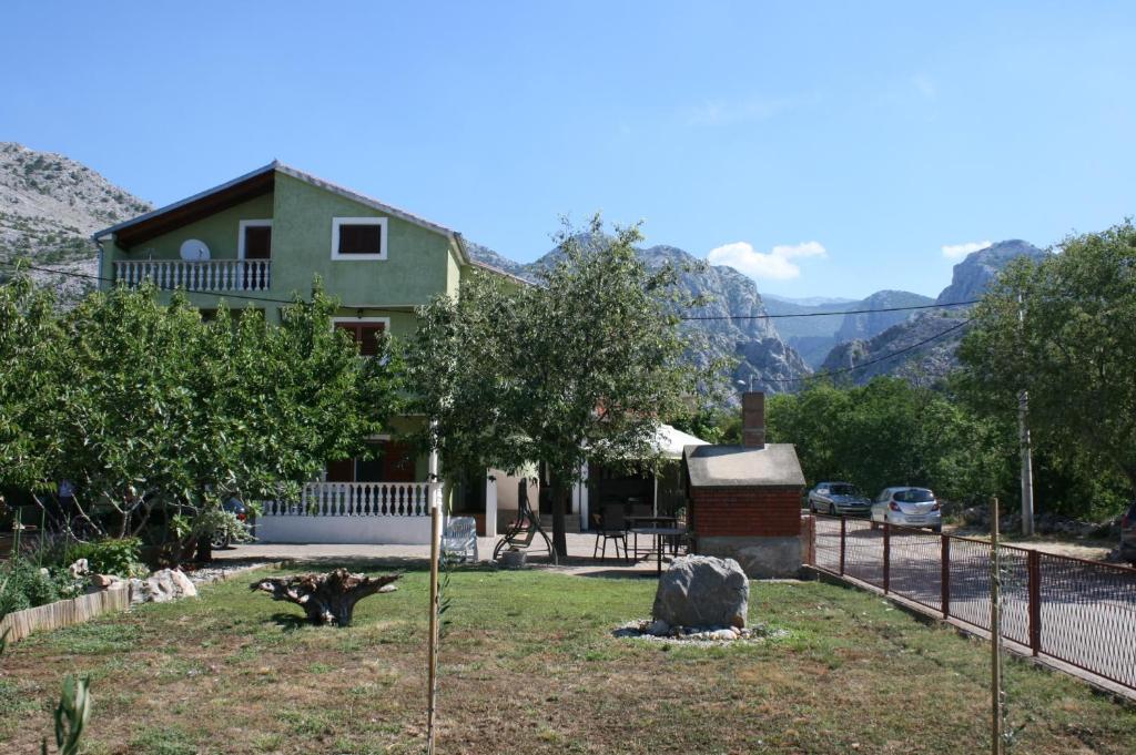 a house with a fence and mountains in the background at Apartment Starigrad 6606b in Starigrad