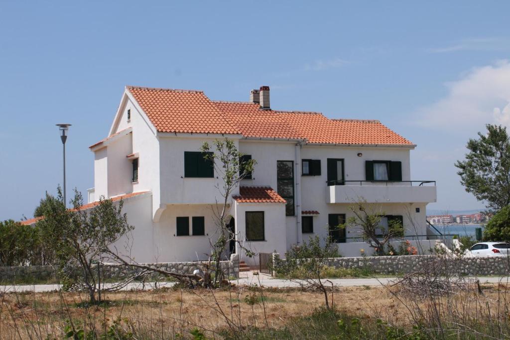 Biały dom z czerwonym dachem w obiekcie Apartment Povljana 6502a w mieście Povljana