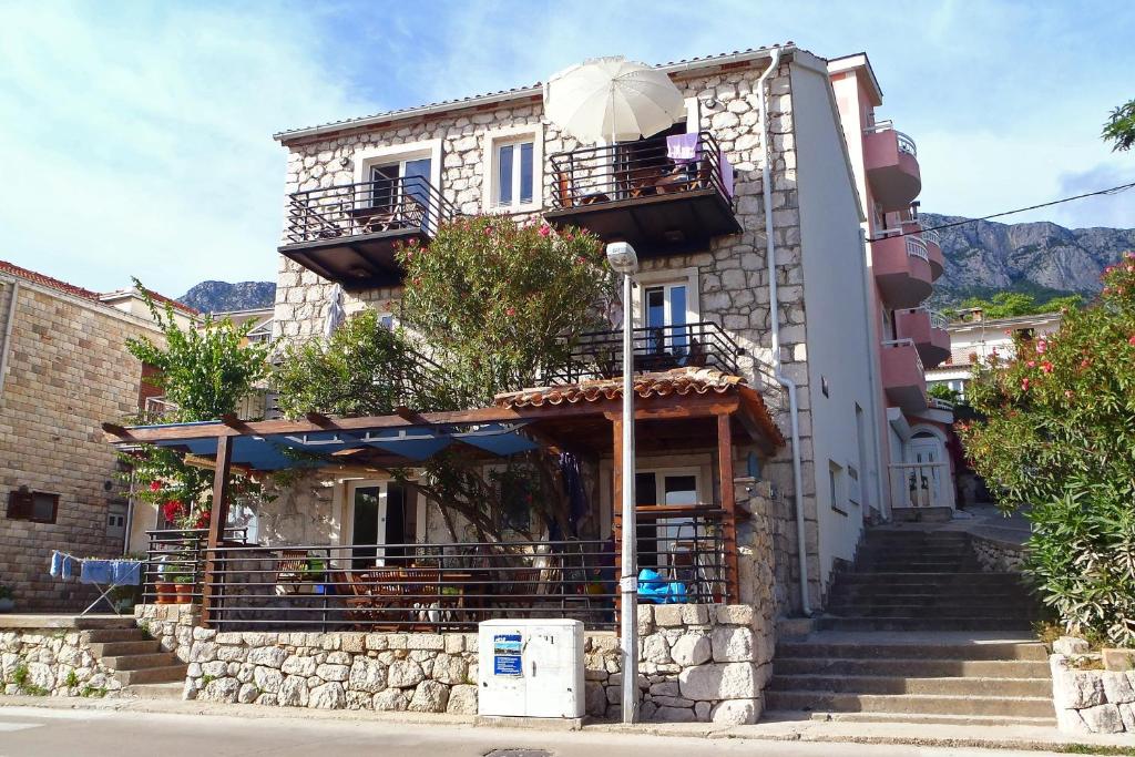 a building with stairs and an umbrella in front of it at Studio Gradac 6661a in Gradac