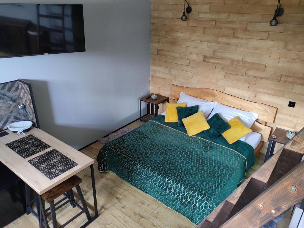 um quarto com uma cama verde e almofadas amarelas em Zdomek em Teplice nad Metují