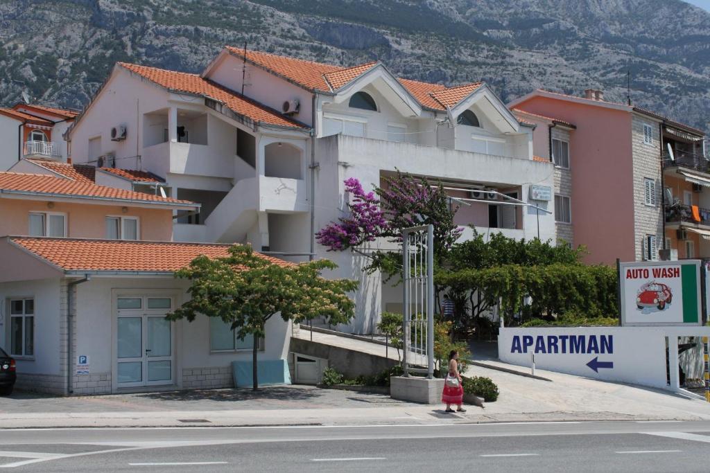 uma mulher a andar numa rua em frente a um edifício em Studio Makarska 6696a em Makarska