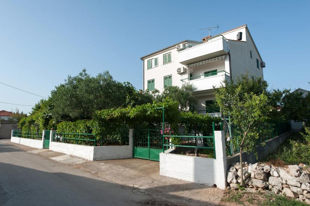 un edificio blanco con una valla al lado de una calle en Studio Turanj 6445b, en Turanj