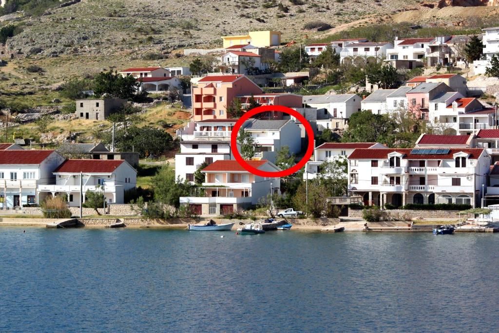 a red circle on a building next to a body of water at Double Room Metajna 6496b in Metajna