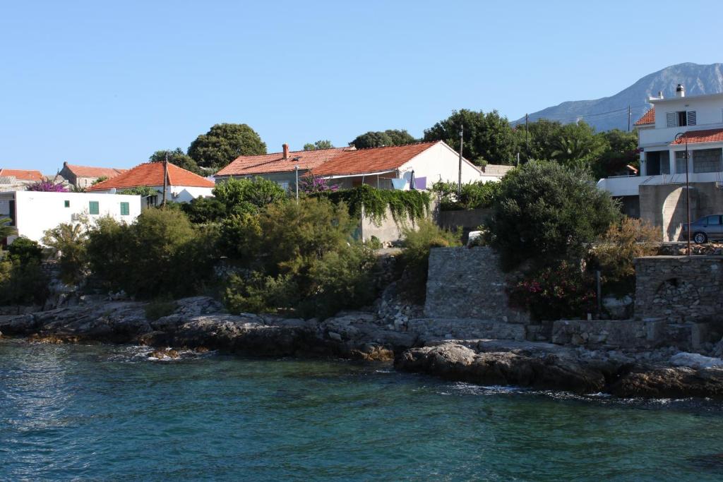 a group of houses on the shore of the water at Double Room Sucuraj 6734b in Sućuraj