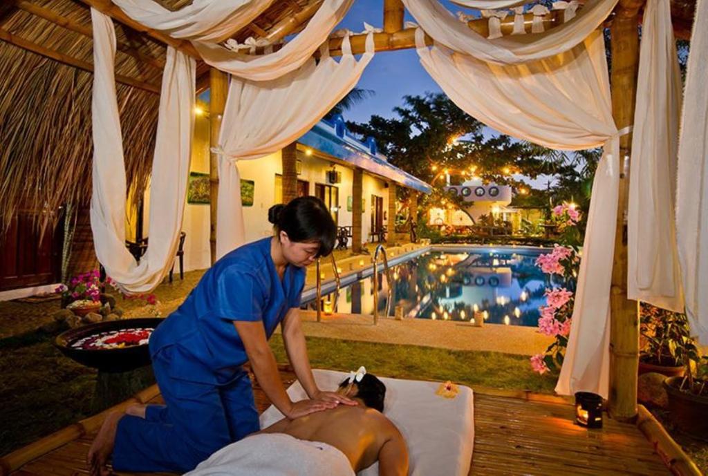 a woman waxing a mans back in front of a pool at Floral Villarosa in Puerto Princesa City