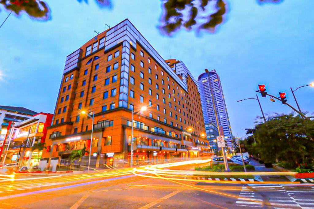 a large building on a city street at night at Bayview Park Hotel Manila in Manila