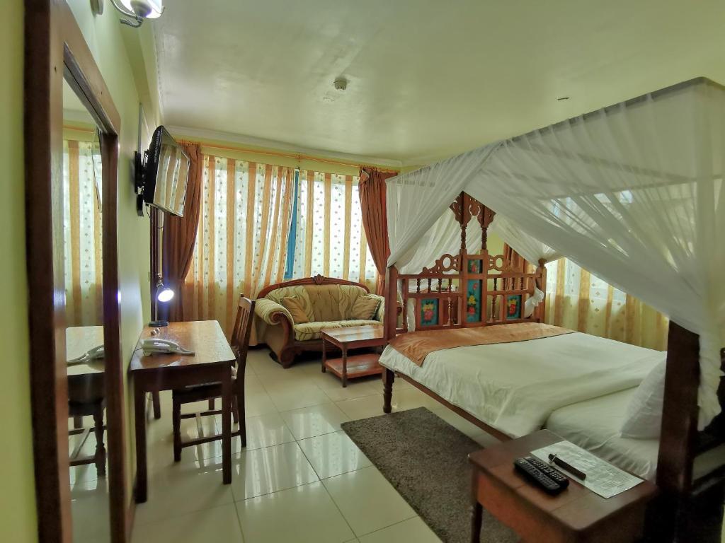 a bedroom with a bed and a chair and a table at New Safari Hotel 