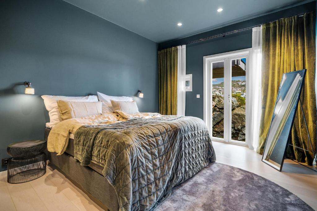 Un dormitorio con una cama con paredes azules y una ventana en "Villa Bergen" 2min from beach & 10min from city centre, en Bergen