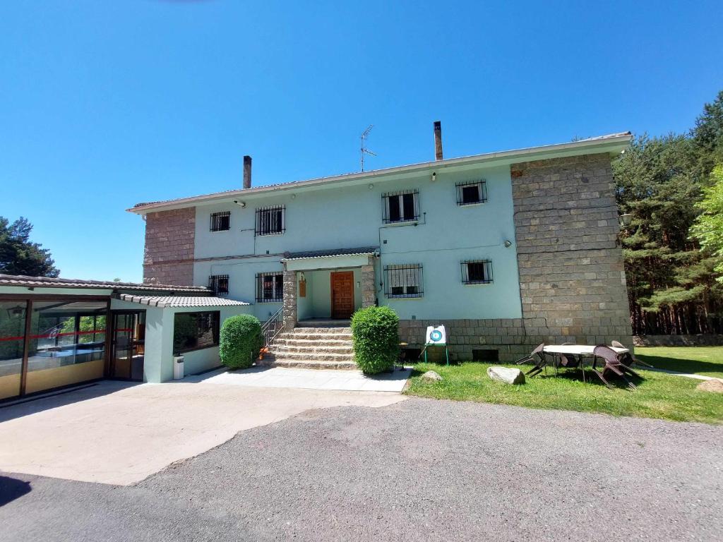 a large white building with a driveway in front of it at La Vista de Gredos in Navarredonda de Gredos