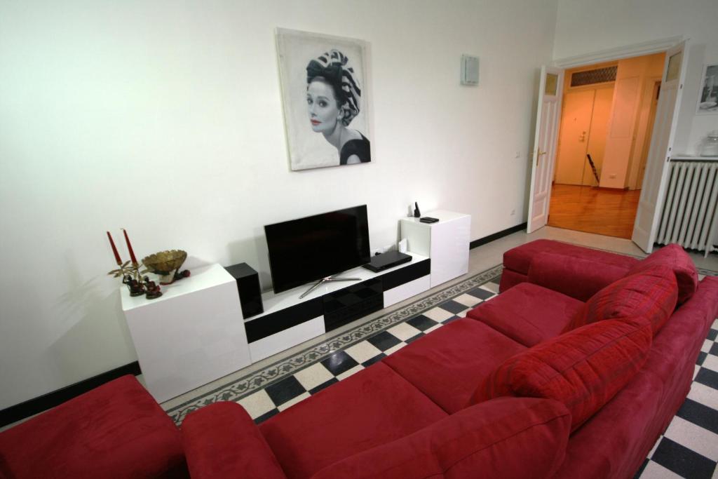 ローマにあるIrene's Home The Residenceのリビングルーム(赤いソファ、テレビ付)