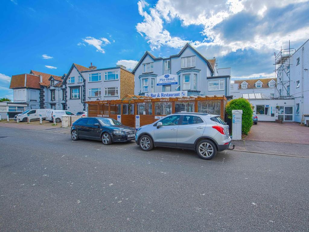 two cars parked in a parking lot in front of a building at OYO Pier Hotel in Clacton-on-Sea