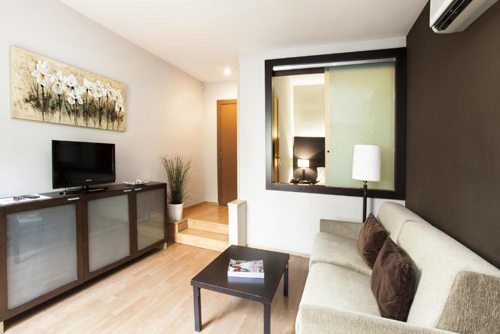 a living room with a couch and a tv at Senator Barcelona Apartments in Barcelona