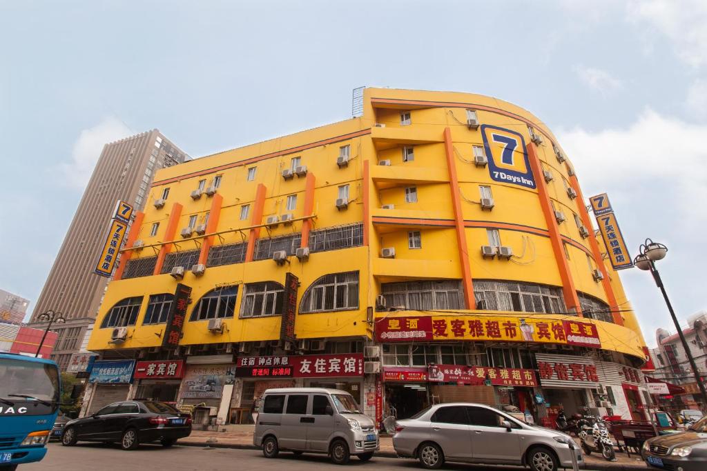 un bâtiment jaune avec des voitures garées devant lui dans l'établissement 7Days Premium Beijing Wangjing Nanhu Dongyuan, à Pékin