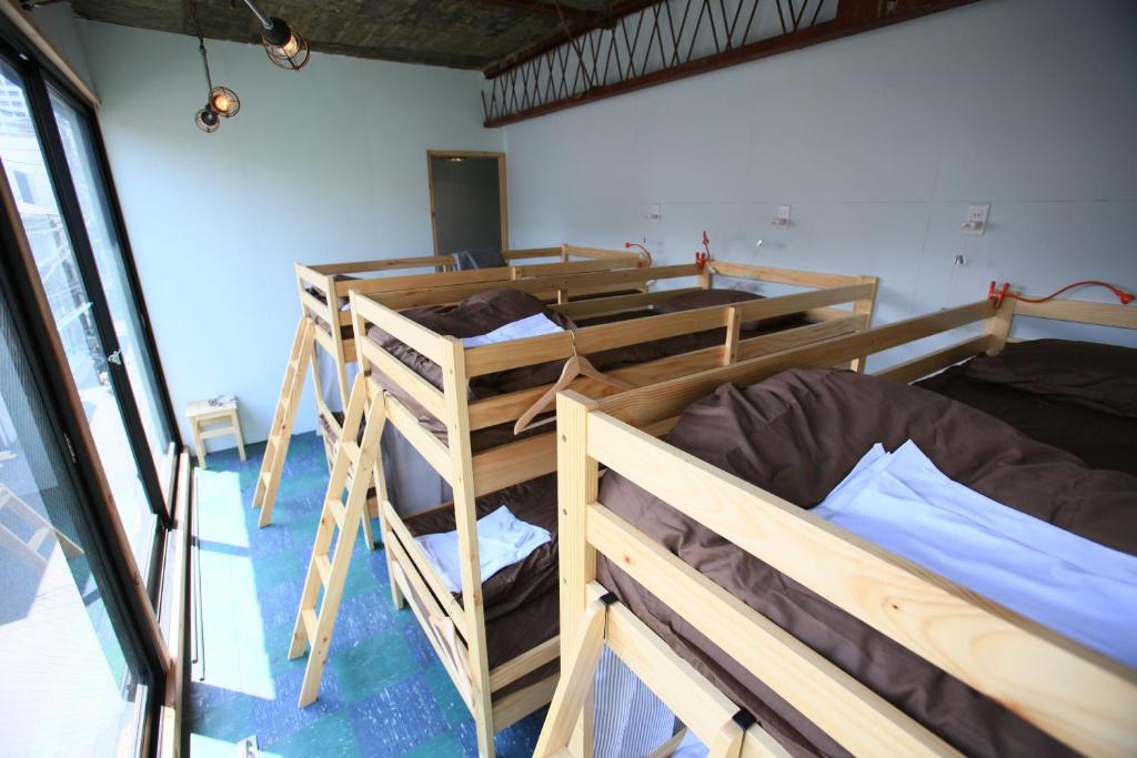 Postel nebo postele na pokoji v ubytování Kamp Houkan-cho Backpacker's Inn & Lounge