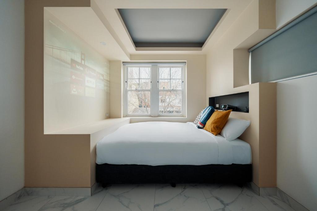 a bedroom with a bed and a window at Cozy M Hotel in Sydney
