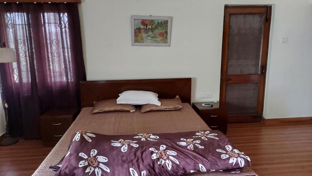 a bed with a purple comforter in a bedroom at vera home stay in Dehradun