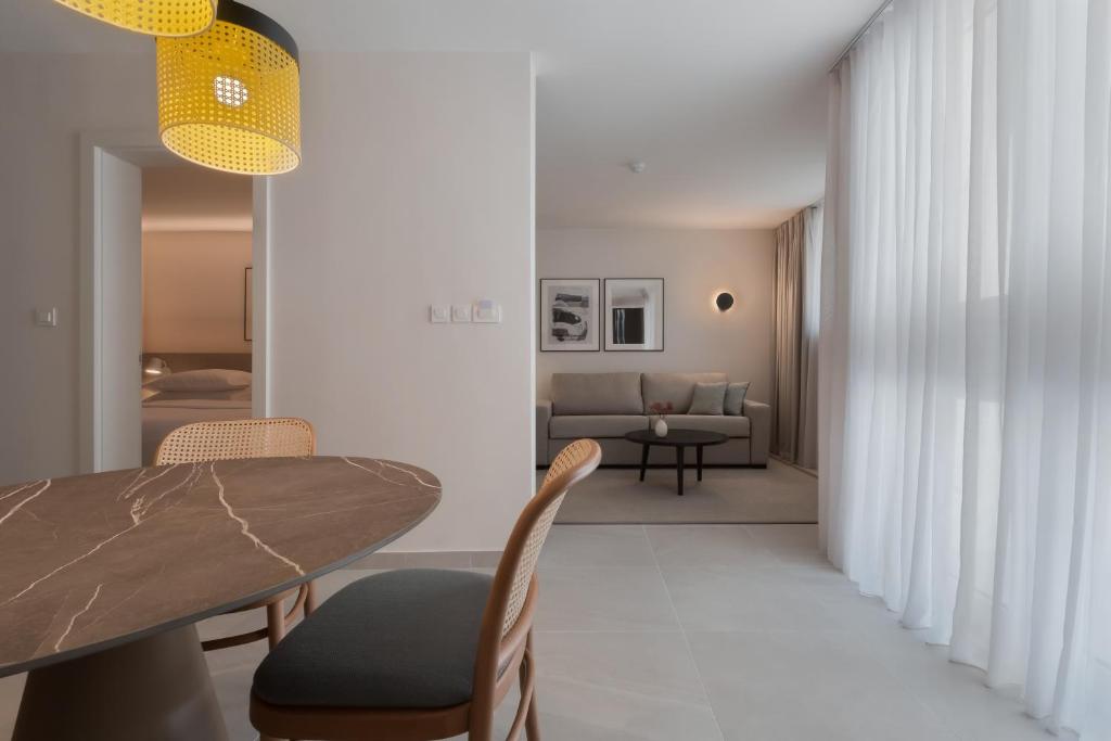 a dining room and living room with a table and chairs at Bluesun Holiday Village Bonaca - Full Board Plus in Bol