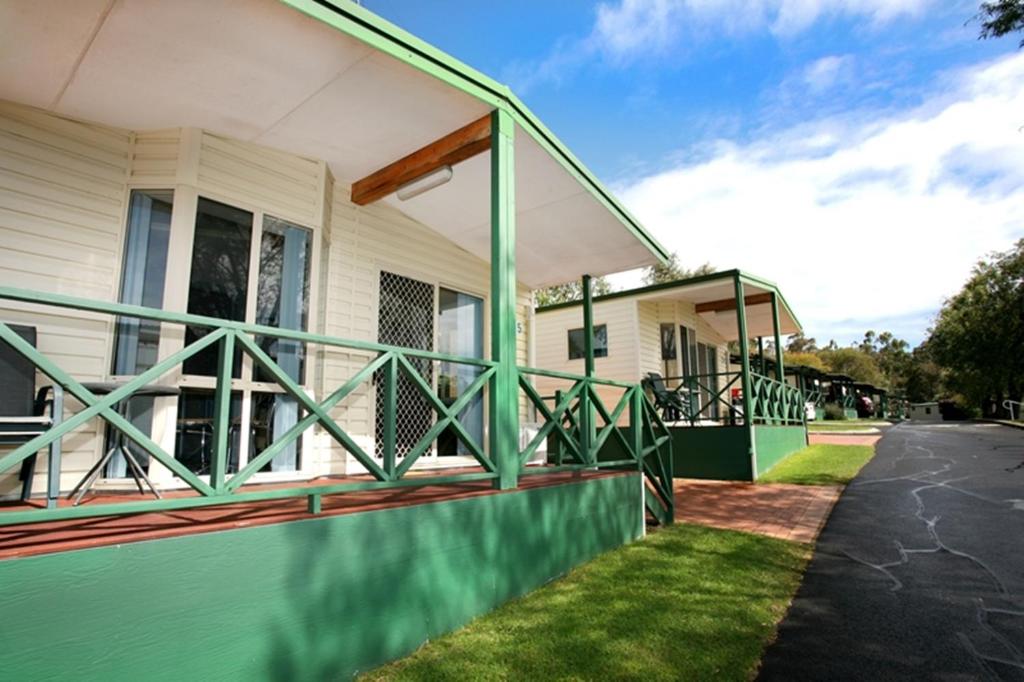 eine Veranda eines Hauses mit grünem Geländer in der Unterkunft Riverview Tourist Park in Margaret River Town