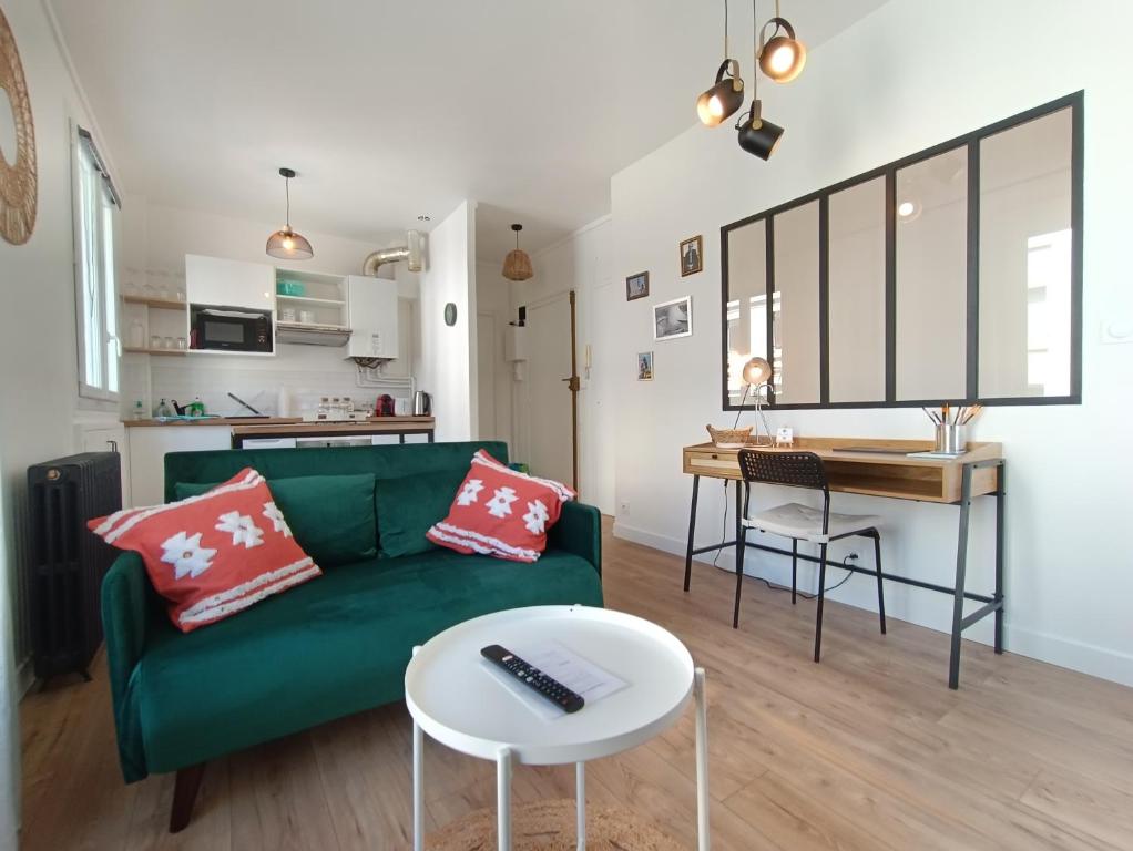 a living room with a green couch and a table at L'Atelier d'Oscar in Le Havre