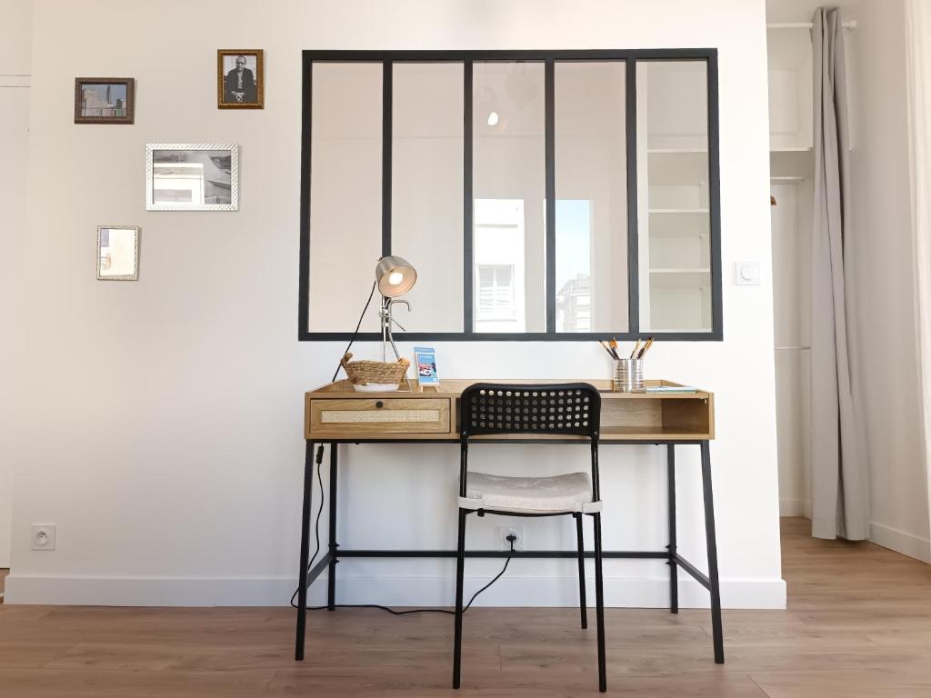 a desk with a chair and a mirror at L&#39;Atelier d&#39;Oscar in Le Havre