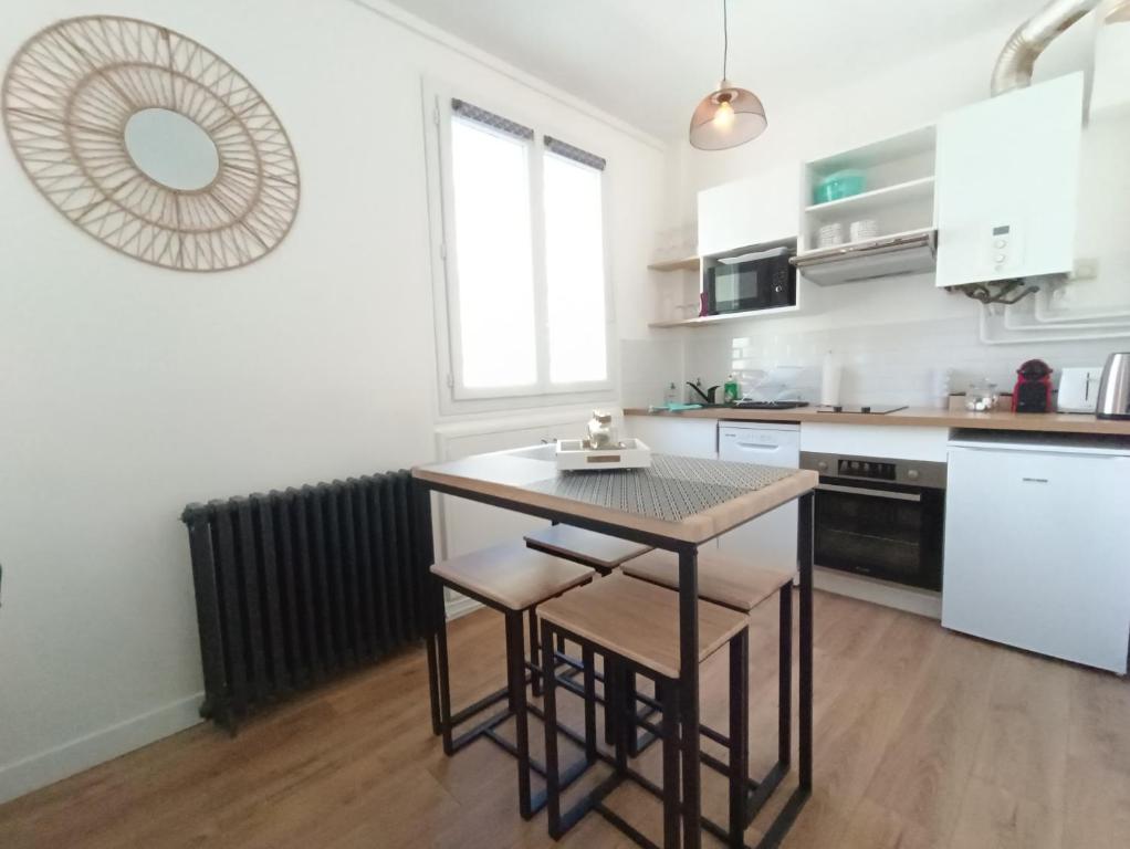 a kitchen with a table and chairs in a room at L&#39;Atelier d&#39;Oscar in Le Havre