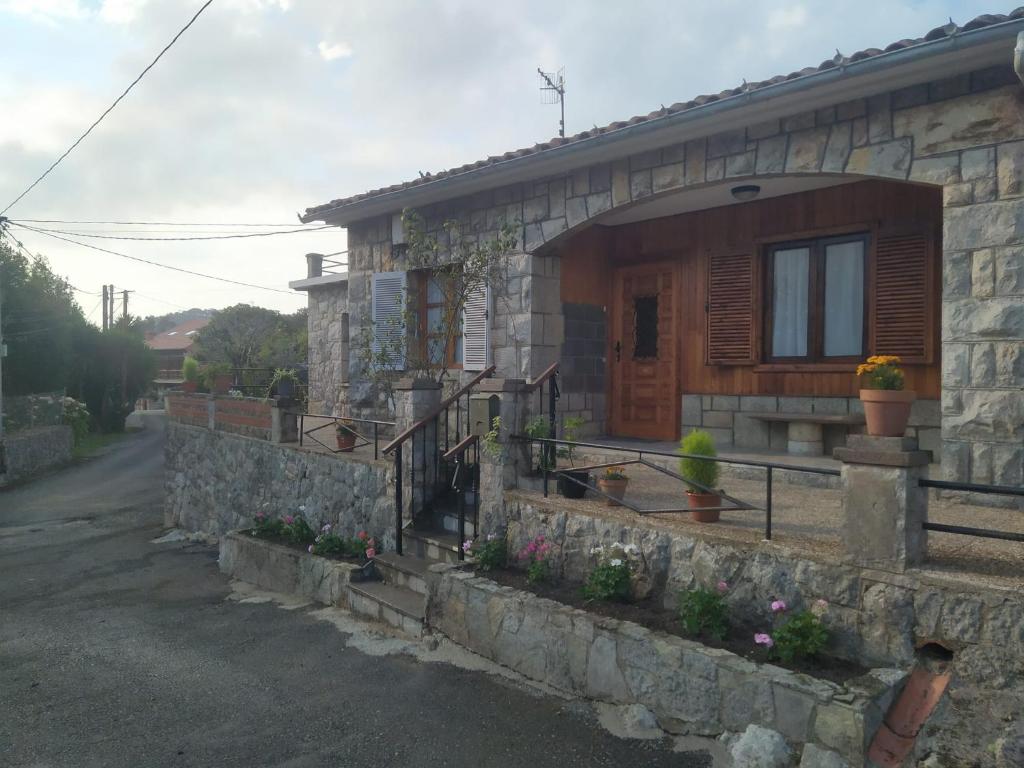 uma casa de pedra com um alpendre e uma porta em Villa Noriega (La Franca) em La Franca