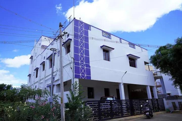 a building with a blue detailing on the side of it at WHITE HOUSE- 1BK Pleasant Apartment with Open Terrace in Coimbatore