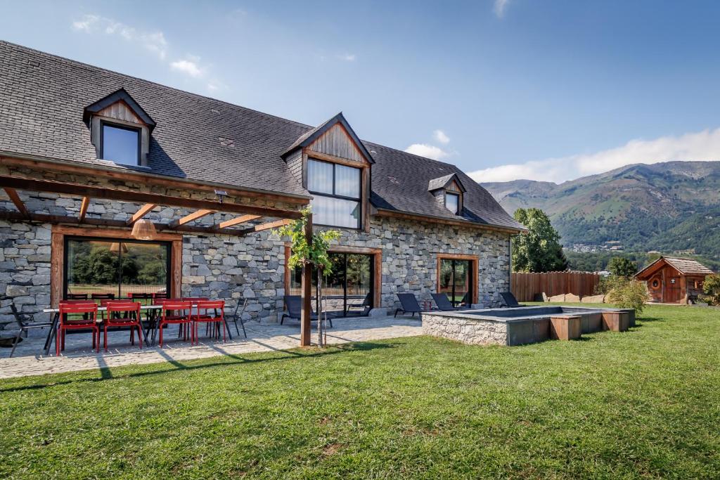 a stone house with a picnic table and a patio at Pyrénées Prestige - Villas d'exceptions et hébergements insolites in Argelès-Gazost