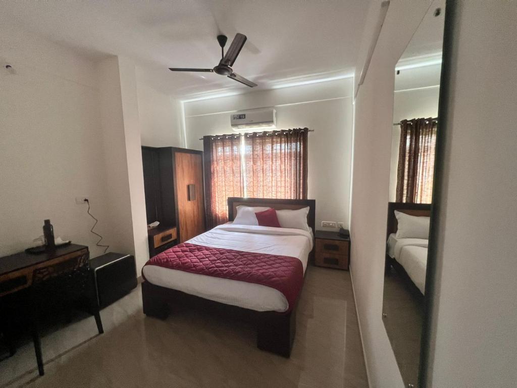 a bedroom with a bed and a dresser and a mirror at NIDHI RESIDENCY in Guruvāyūr